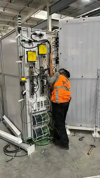 Technician checking electrical connections during industrial installation