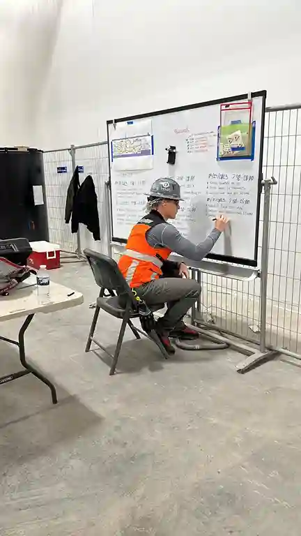 Engineer writing process notes and planning industrial tasks on whiteboard